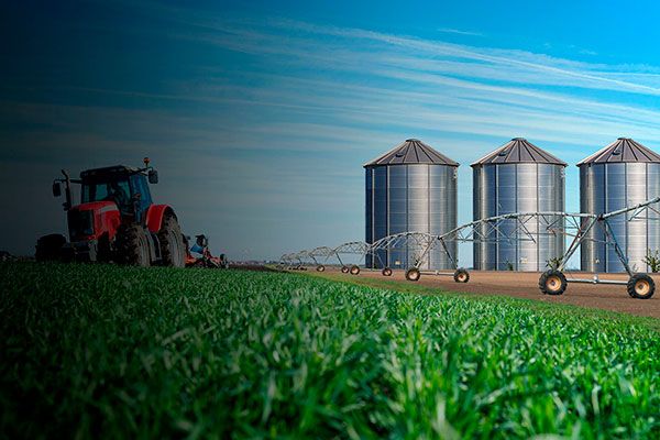 foto de um trator no campo ao lado de um agronegócio.