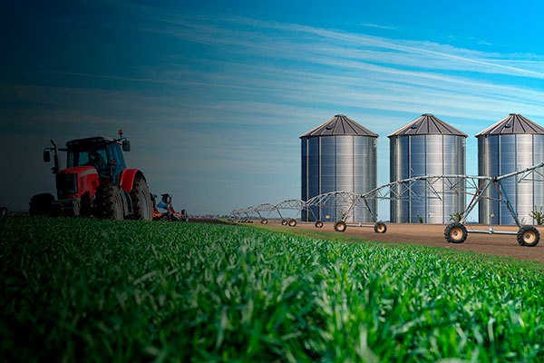 foto de um trator no campo ao lado de um agronegócio.